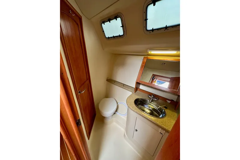 Slide: The Image of 2008 Hunter 49 yacht bathroom with sink, toilet, and wooden cabinetry. - 74