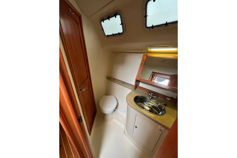 Slide: The Image of 2008 Hunter 49 yacht bathroom with sink, toilet, and wooden cabinetry. - 75