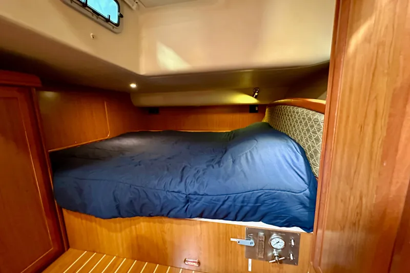 Slide: The Image of Cozy cabin interior of 2008 Hunter 49 yacht with blue bedding and wooden finish. - 78