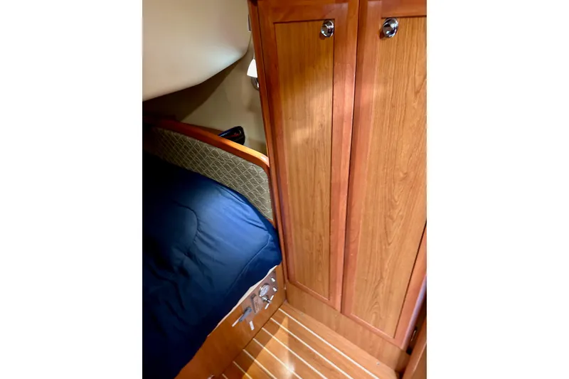 Slide: The Image of Cozy cabin interior of 2008 Hunter 49 sailboat with wooden cabinetry and blue bedding. - 79