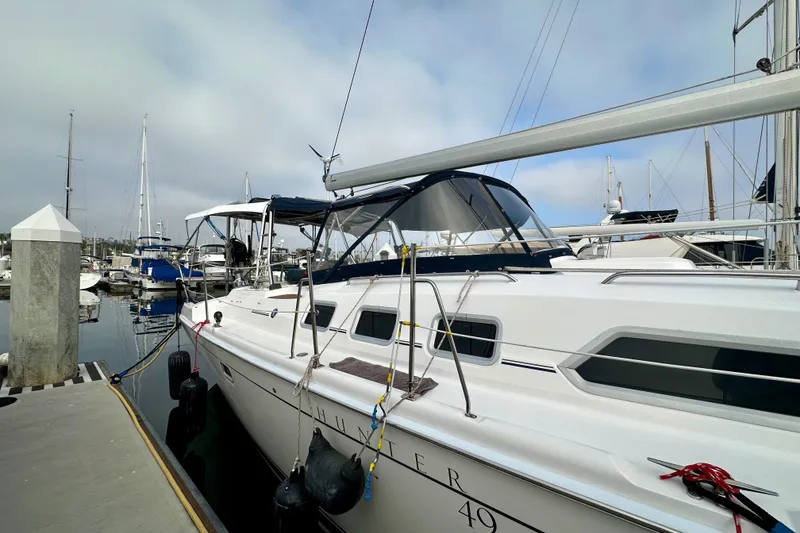 Slide: The Image of 2008 Hunter 49 sailboat docked at marina, featuring sleek design and spacious deck. - 8