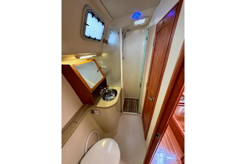Slide: The Image of Compact bathroom in 2008 Hunter 49 yacht with shower, sink, and wooden accents. - 82