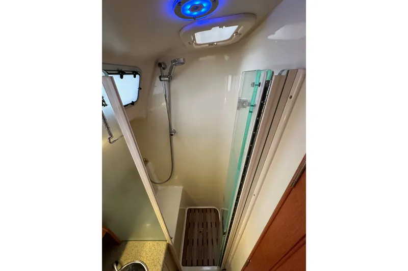 Slide: The Image of Compact shower area in a 2008 Hunter 49 yacht with modern fixtures and blue lighting. - 84