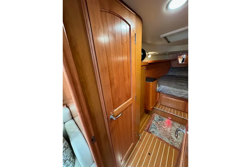 Slide: The Image of Interior of 2008 Hunter 49 sailboat with wooden cabinetry and cozy sleeping area. - 99