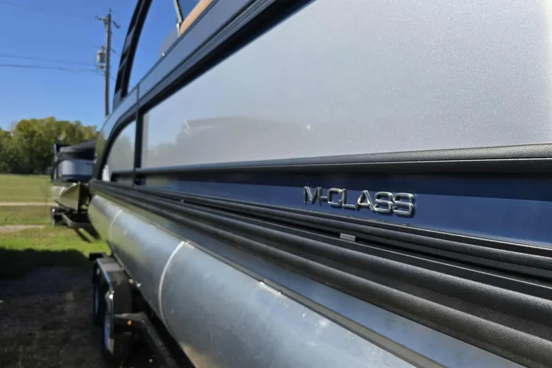 Slide: The Image of 2026 Qwest 22RLS M-Class pontoon boat, side view with sleek design. - 15