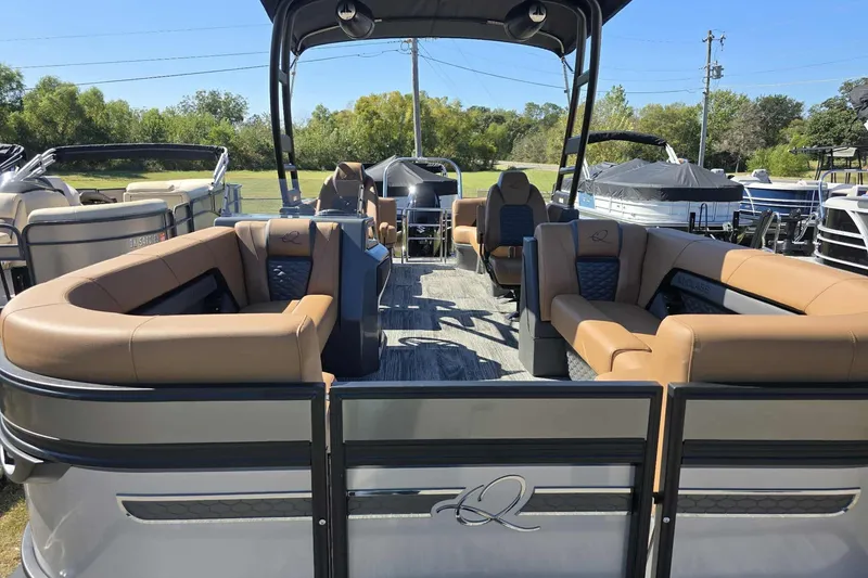 Slide: The Image of 2026 Qwest 22RLS pontoon boat with tan seating, docked outdoors. - 3