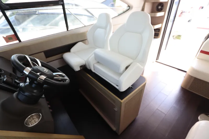 Slide: The Image of Interior of 2020 Azimut Nexus X47 yacht with white captain's chairs and steering wheel. - 19