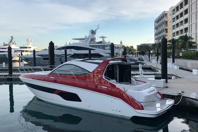 Slide: The Image of 2020 Azimut Nexus X47 yacht docked at a marina, featuring sleek red and white design. - 2
