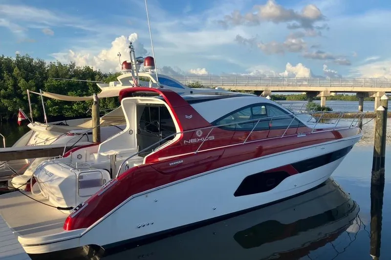 Slide: The Image of 2020 Azimut Nexus X47 yacht docked by a scenic waterfront under a blue sky. - 3