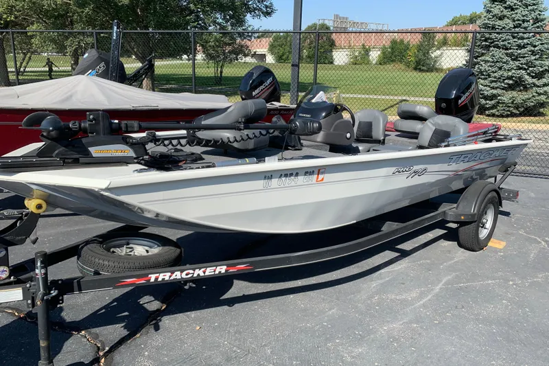 The Image of 2023 Tracker Pro 170 boat on trailer, parked outdoors, featuring Mercury engine. - 0