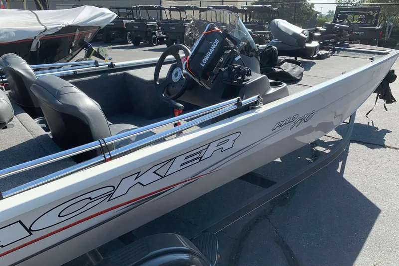 Slide: The Image of 2023 Tracker Pro 170 boat interior with steering wheel and seating in a parking lot. - 5