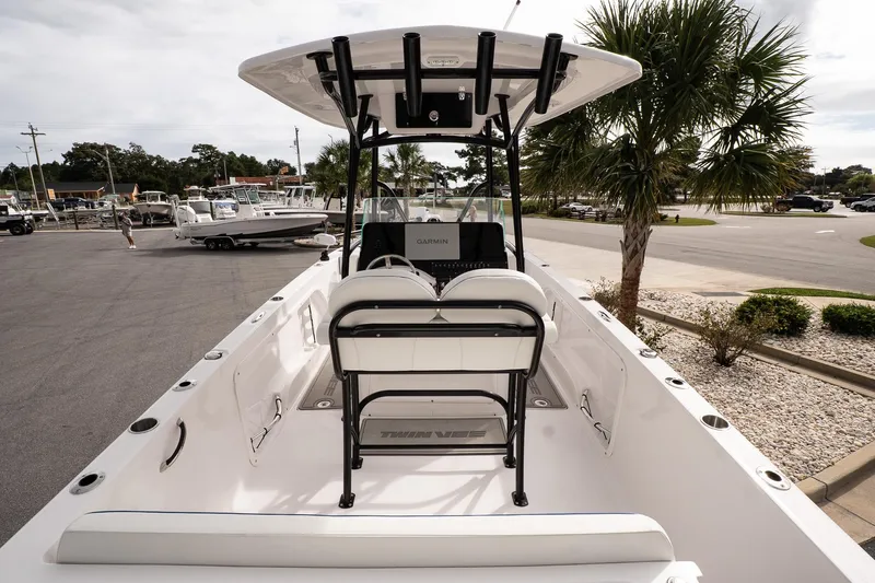 Slide: The Image of 2025 Twin Vee 240 GFX CC boat, white interior, parked near palm trees in a marina. - 10
