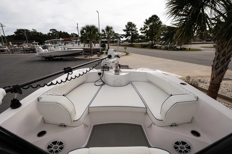 Slide: The Image of 2025 Twin Vee 240 GFX CC boat interior with white seating and palm trees in the background. - 18
