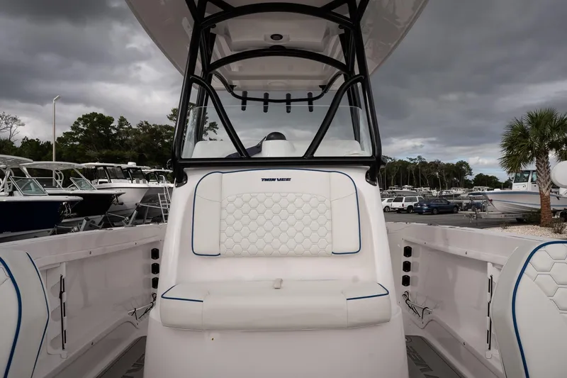 Slide: The Image of 2025 Twin Vee 240 GFX CC boat interior with white seating and overcast sky. - 22