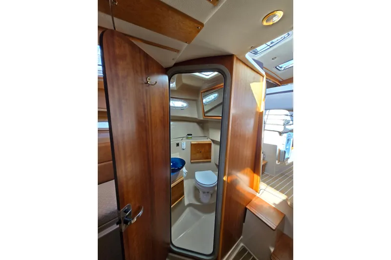 Slide: The Image of 2015 Cutwater C28 boat interior with wooden door and compact bathroom. - 13