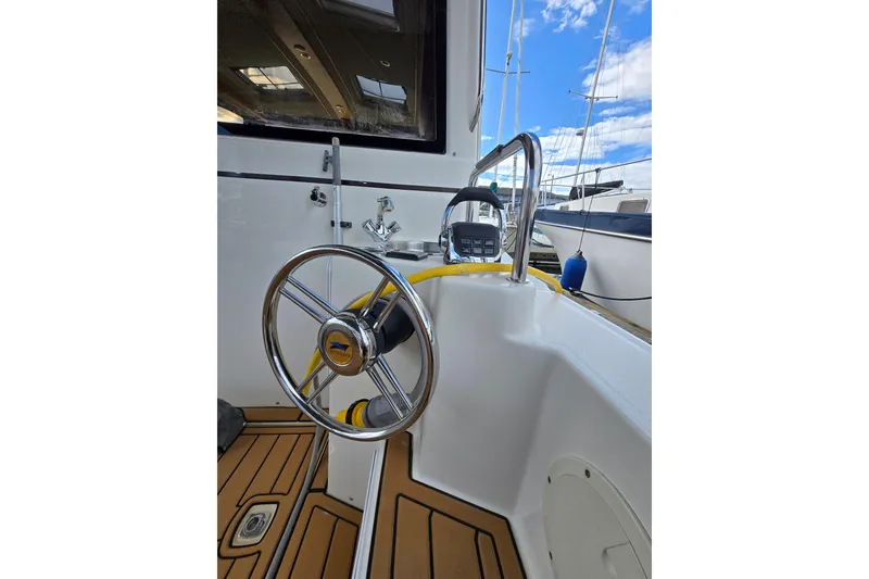 Slide: The Image of 2015 Cutwater C28 boat helm with steering wheel and control panel, docked under blue sky. - 19