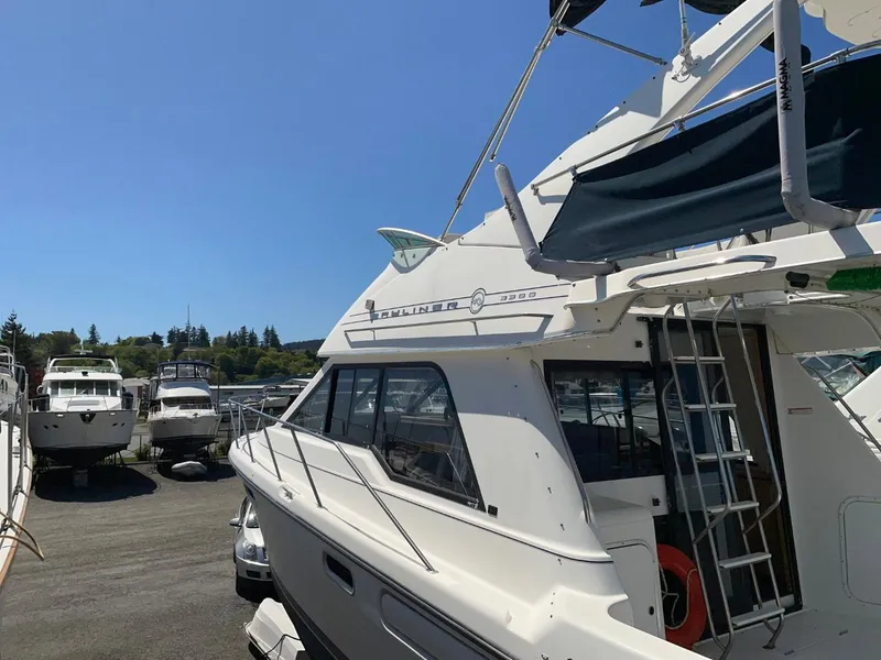 Slide: The Image of 1999 Bayliner 3388 Motoryacht docked in a marina under a clear blue sky. - 1