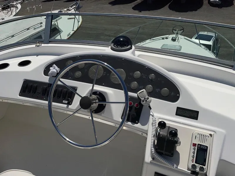 Slide: The Image of 1999 Bayliner 3388 Motoryacht helm with steering wheel and navigation controls. - 12