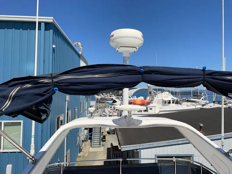 Slide: The Image of 1999 Bayliner 3388 Command Bridge Motoryacht docked at marina, blue sky background. - 15