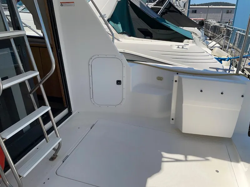 Slide: The Image of 1999 Bayliner 3388 Motoryacht deck area with ladder and storage compartments. - 16