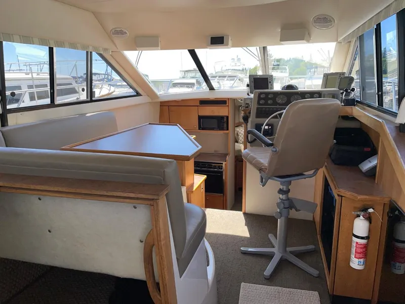 Slide: The Image of 1999 Bayliner 3388 Motoryacht interior with helm, seating, and dining area. - 19