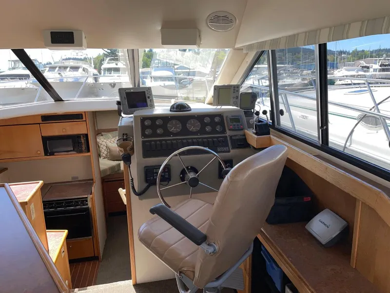 Slide: The Image of 1999 Bayliner 3388 Motoryacht helm with navigation equipment and marina view. - 23