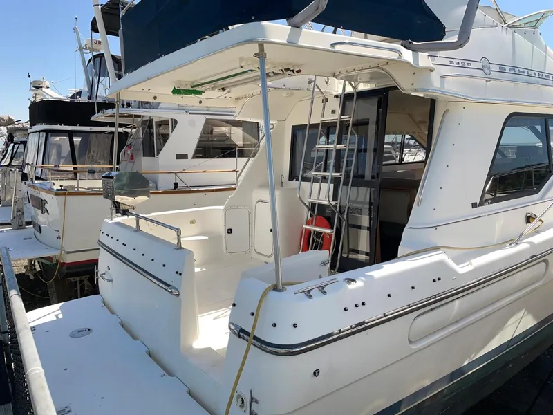 Slide: The Image of 1999 Bayliner 3388 Motoryacht docked at a marina, rear view. - 3