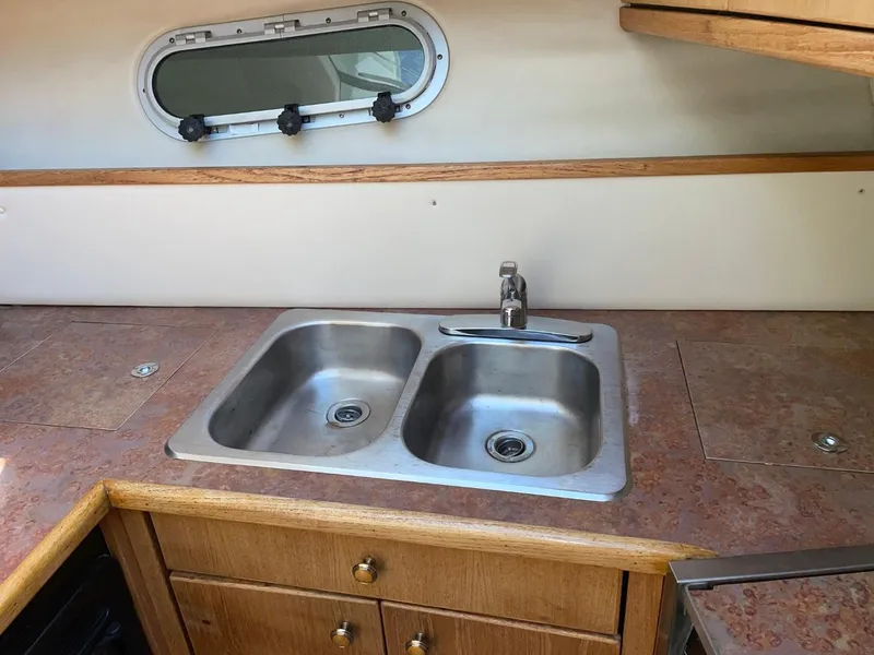 Slide: The Image of 1999 Bayliner 3388 Motoryacht kitchen with double stainless steel sink and wooden cabinetry. - 33