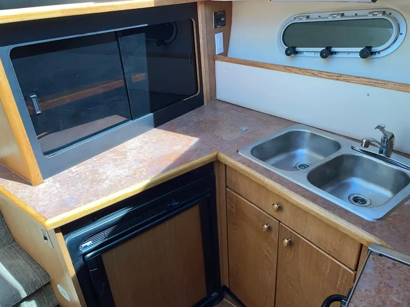 Slide: The Image of 1999 Bayliner 3388 Motoryacht kitchen with double sink, stove, and storage cabinets. - 36