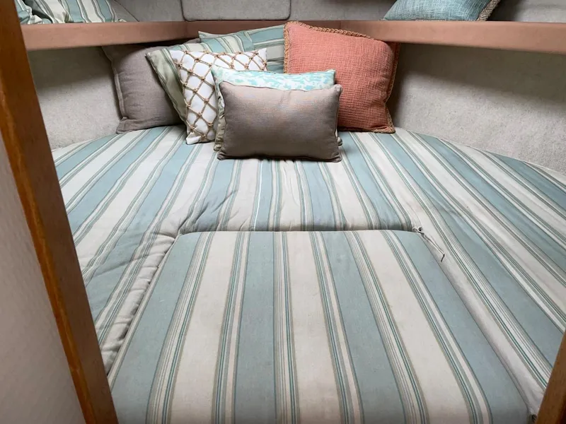 Slide: The Image of 1999 Bayliner 3388 Motoryacht cozy cabin with striped bedding and decorative pillows. - 37
