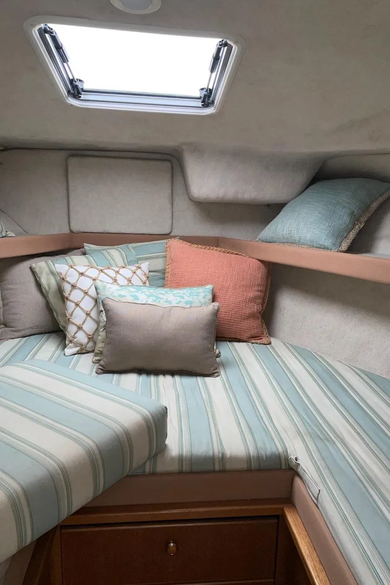 Slide: The Image of Cozy cabin interior of a 1999 Bayliner 3388 Motoryacht with striped bedding and decorative pillows. - 39