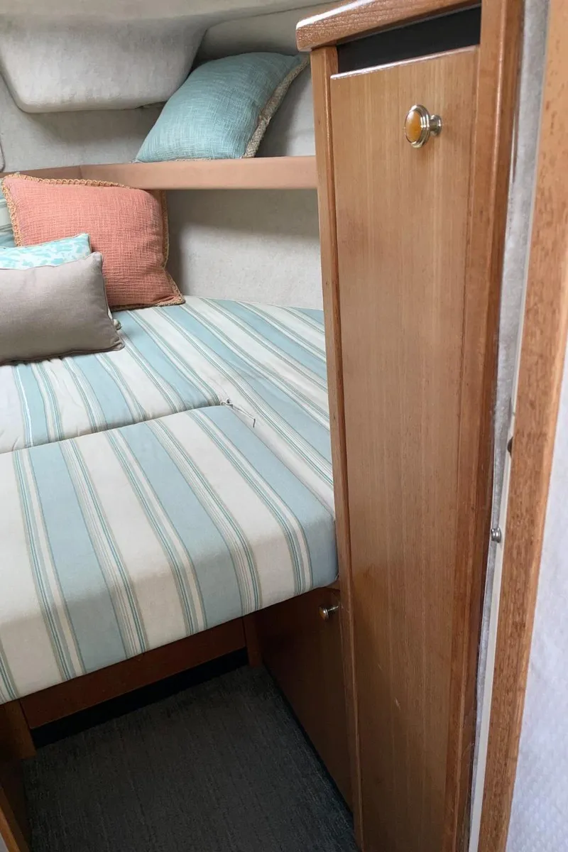 Slide: The Image of Cozy cabin interior of a 1999 Bayliner 3388 Motoryacht with striped bedding and pillows. - 40