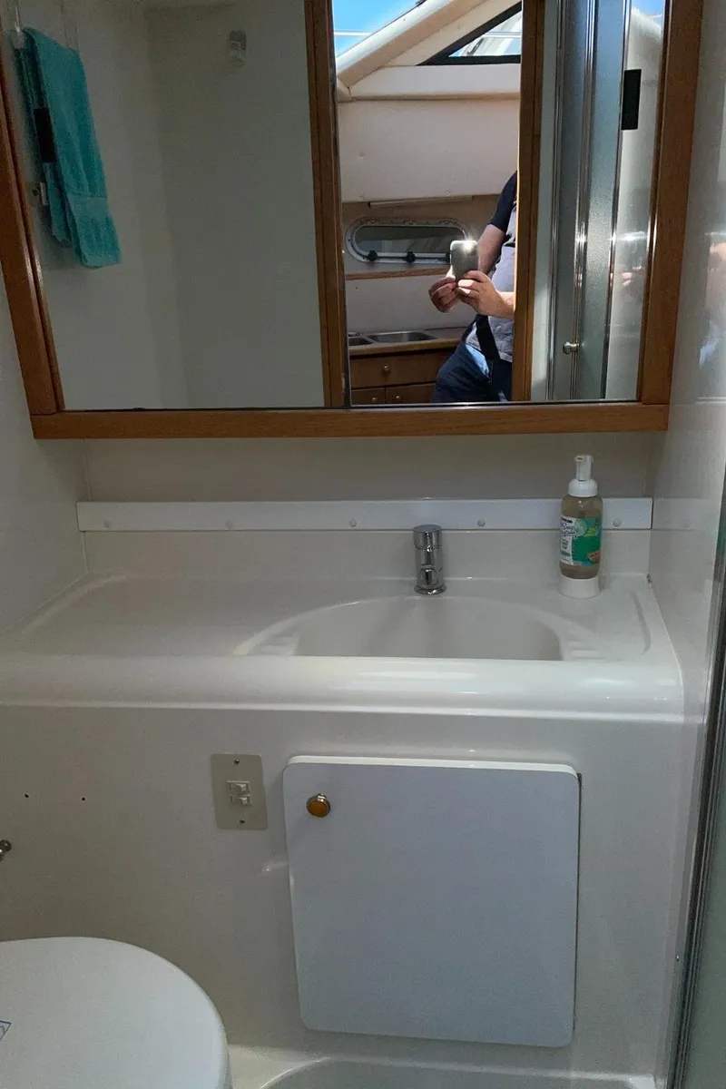 Slide: The Image of Bathroom sink area in 1999 Bayliner 3388 Motoryacht with mirror and storage. - 42