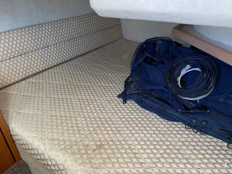 Slide: The Image of 1999 Bayliner 3388 Motoryacht interior cabin with patterned bedding and stored gear. - 48