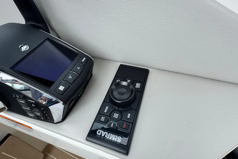 Slide: The Image of 2025 Saxdor 400 GTO dashboard with controls and Simrad device, near water. - 35
