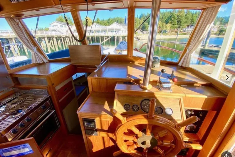 Slide: The Image of 1984 Grand Banks 36 Classic yacht interior with wooden helm and kitchen area. - 17