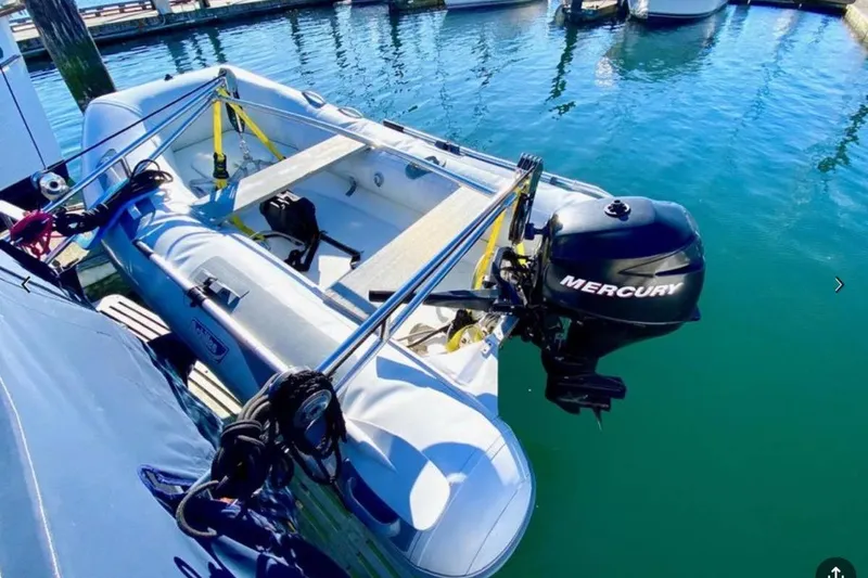 Slide: The Image of Inflatable boat with Mercury outboard motor docked beside a Grand Banks 36 Classic, 1984 model. - 7