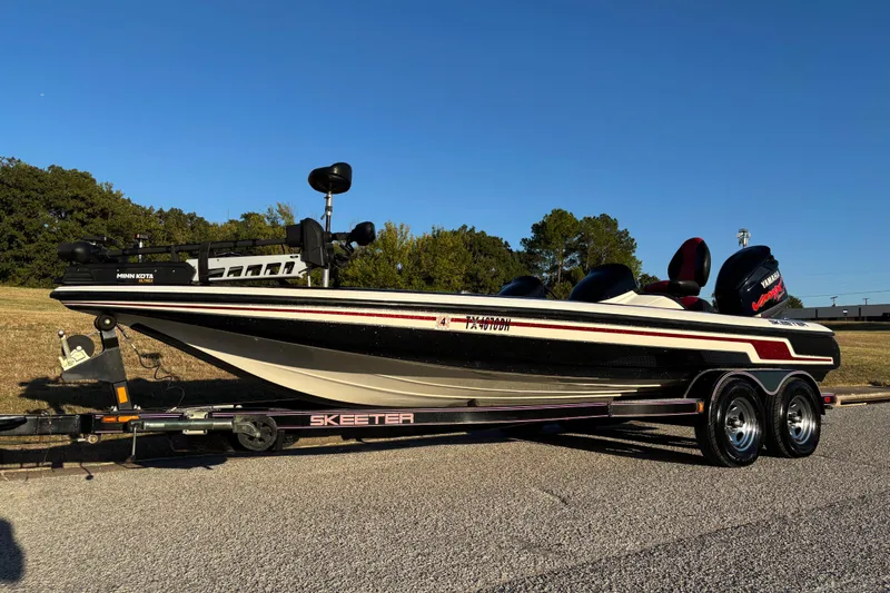The Image of 2011 Skeeter ZX250 boat on trailer by a lake, ready for launch. - 0