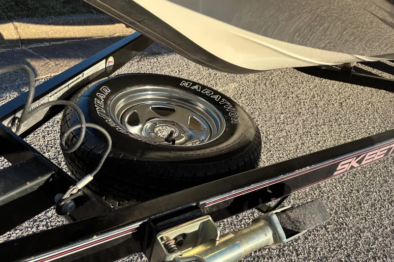 Slide: The Image of 2011 Skeeter ZX250 boat cockpit with dual consoles and red seats under clear blue sky. - 14