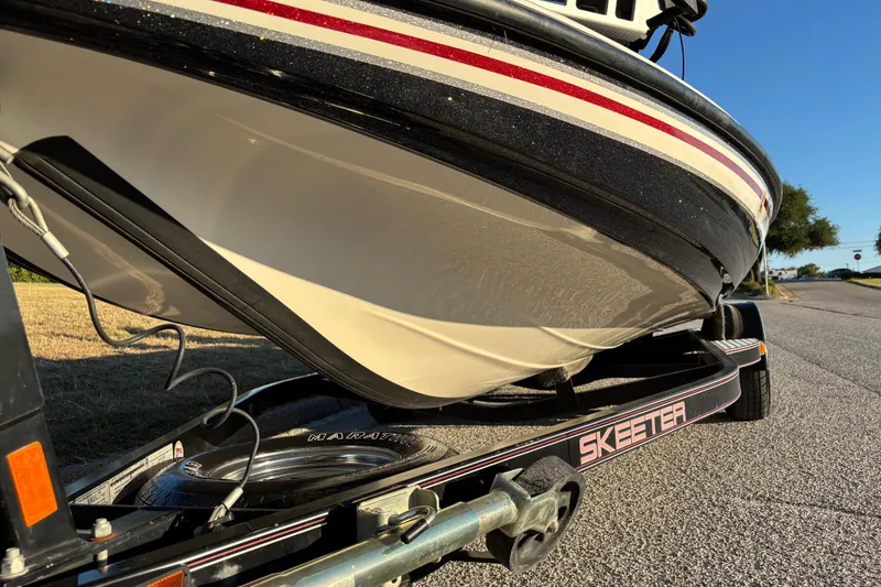 Slide: The Image of 2011 Skeeter ZX250 boat trailer with Minn Kota Ultrex motor on pavement. - 16