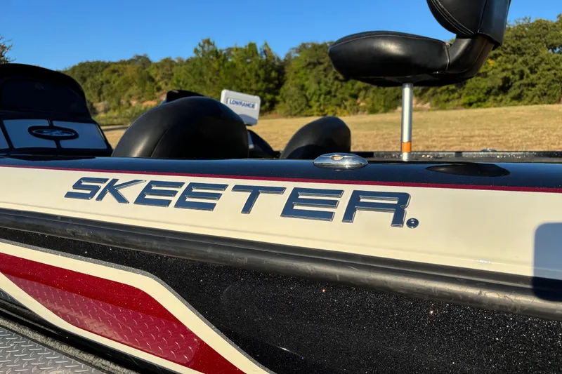 Slide: The Image of 2011 Skeeter ZX250 boat on a dual-axle trailer, parked outdoors. - 22