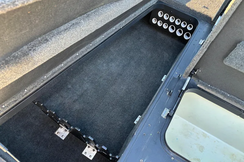 Slide: The Image of 2011 Skeeter ZX250 boat storage compartments with carpeted interior and hydraulic lift supports. - 49