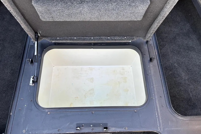Slide: The Image of 2011 Skeeter ZX250 boat storage compartment with rod holders and carpeted interior. - 50