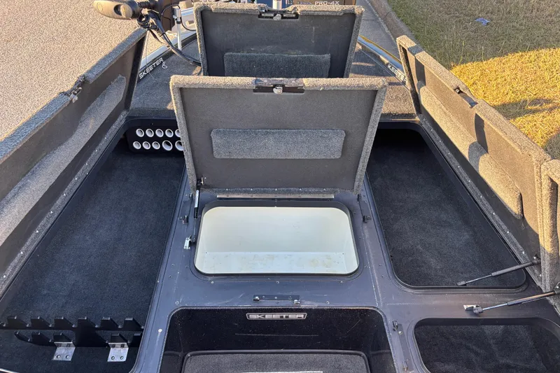 Slide: The Image of Open storage compartment in 2011 Skeeter ZX250 boat, featuring carpeted interior. - 51
