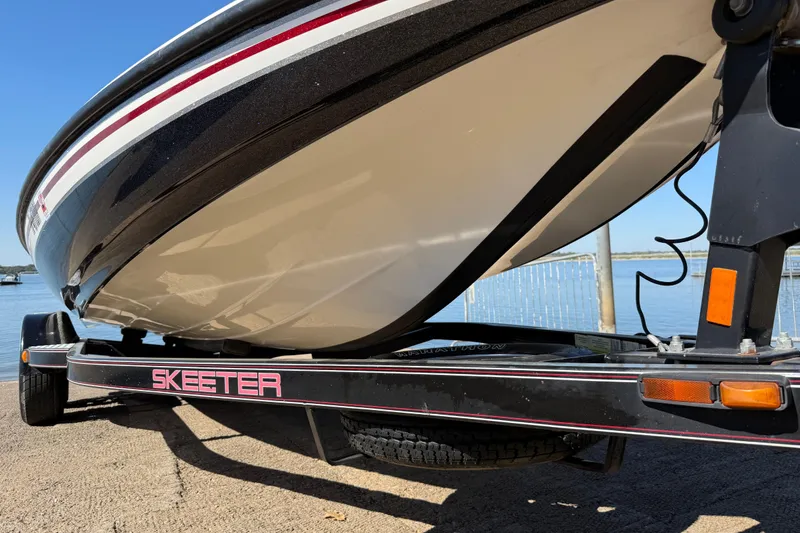 Slide: The Image of 2011 Skeeter ZX250 boat on trailer by the water, showcasing sleek design. - 71