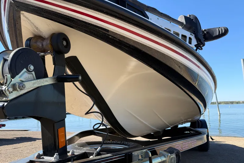 Slide: The Image of 2011 Skeeter ZX250 boat on trailer by the water, close-up view. - 72
