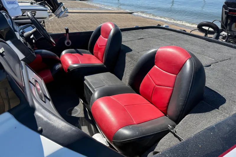 Slide: The Image of 2011 Skeeter ZX250 boat interior with red and black seats by the water. - 76