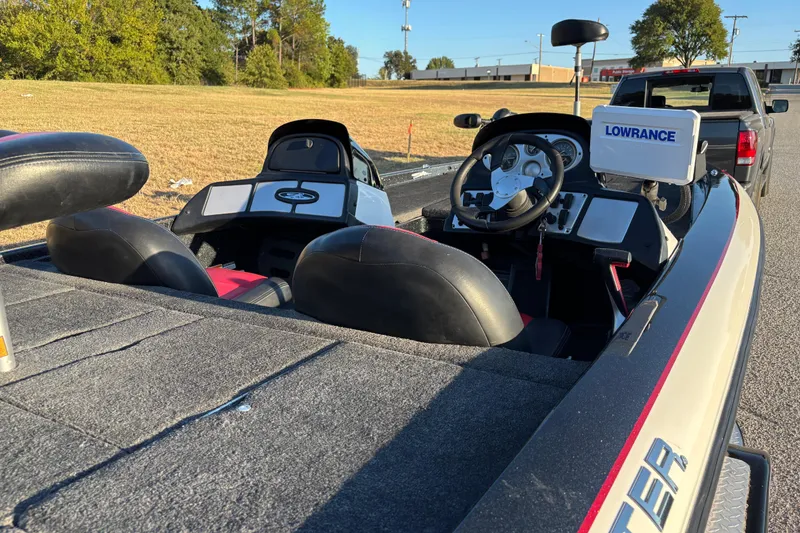 Slide: The Image of 2011 Skeeter ZX250 bass boat on trailer, parked on a road with trees in the background. - 9