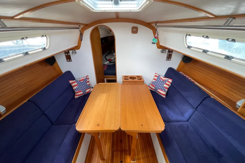 Slide: The Image of 2001 J Boats J/32 interior with blue seating, wooden table, and nautical decor. - 17