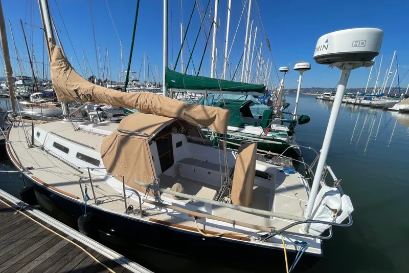 Slide: The Image of 2001 J Boats J/32 sailboat docked in marina, featuring tan covers and clear blue sky. - 5